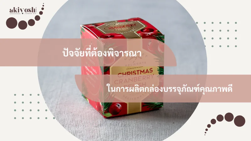 ภาพกล่อง Christmas Cranberry ออกแบบสวยงามสำหรับเทศกาล พร้อมข้อความ 'ปัจจัยที่ต้องพิจารณาในการผลิตกล่องบรรจุภัณฑ์คุณภาพดี' และโลโก้ Akiyoshi